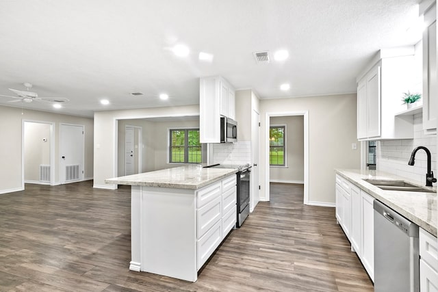 kitchen featuring light stone countertops, appliances with stainless steel finishes, sink, and white cabinets