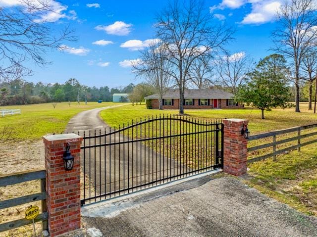 view of gate with a yard