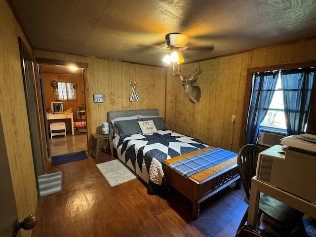 bedroom featuring ceiling fan, cooling unit, dark wood-type flooring, and wood walls