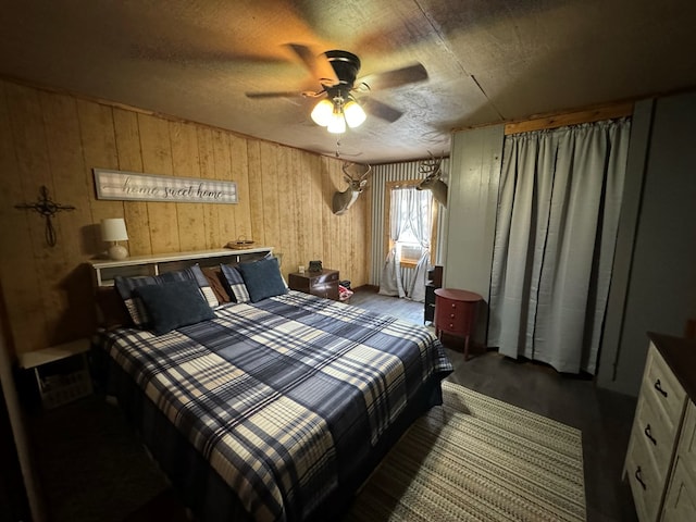 bedroom featuring dark hardwood / wood-style flooring, ceiling fan, and wooden walls