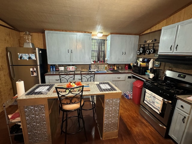 kitchen featuring appliances with stainless steel finishes, exhaust hood, a center island, dark hardwood / wood-style floors, and lofted ceiling