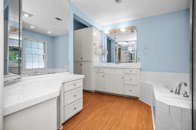 715 Pine Tree Ln, Lufkin, TX 75904 - full bathroom with wood finished floors, two vanities, and a garden tub