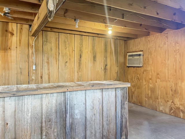 basement with bar area, wood walls, and a wall mounted AC