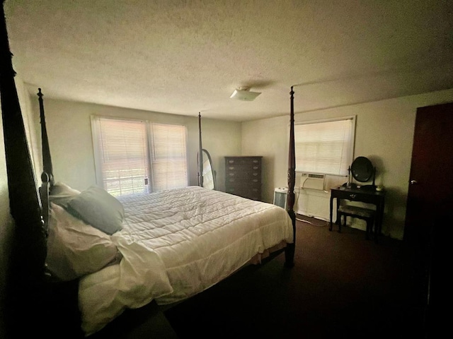 bedroom featuring a textured ceiling and dark colored carpet