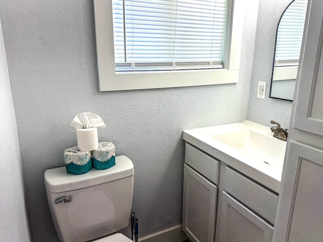 bathroom featuring vanity, a healthy amount of sunlight, and toilet