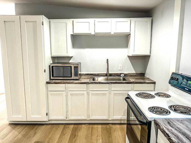 kitchen featuring lofted ceiling, white electric range, sink, light hardwood / wood-style floors, and white cabinetry