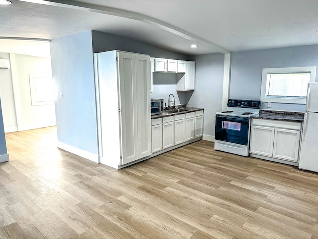 kitchen featuring white cabinetry, sink, light hardwood / wood-style floors, lofted ceiling, and white appliances