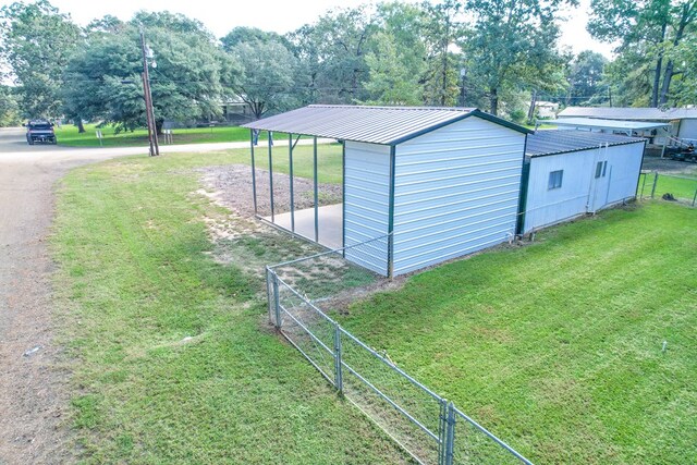 view of outdoor structure featuring a carport and a lawn