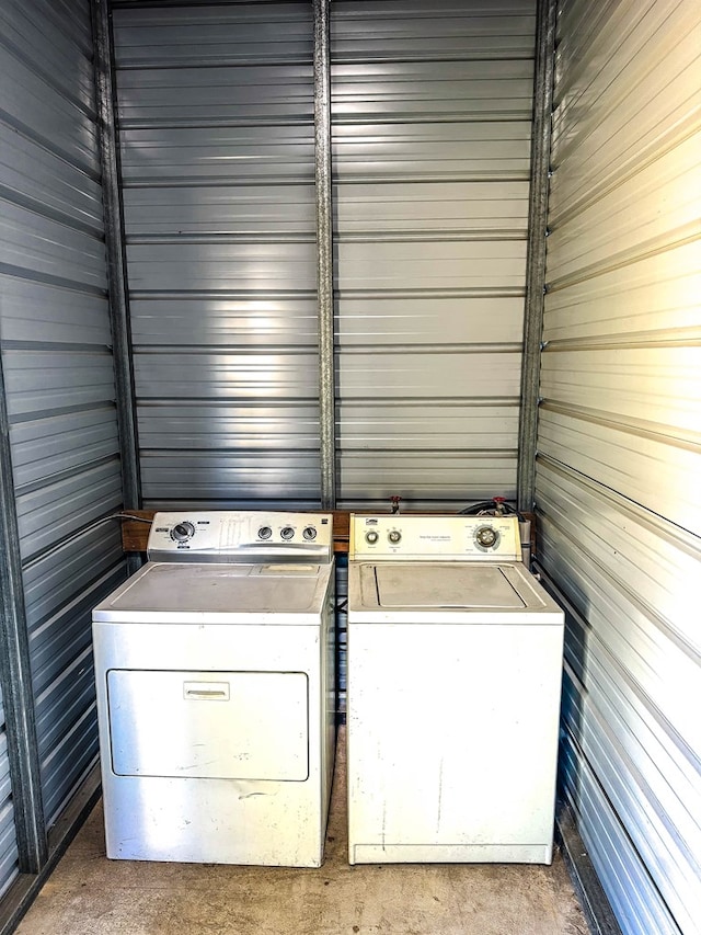 laundry area featuring wood walls and washing machine and dryer