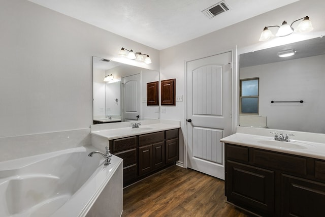801 Dove Run Trl, College Station, TX 77845 - bathroom with two vanities, wood finished floors, and a bath