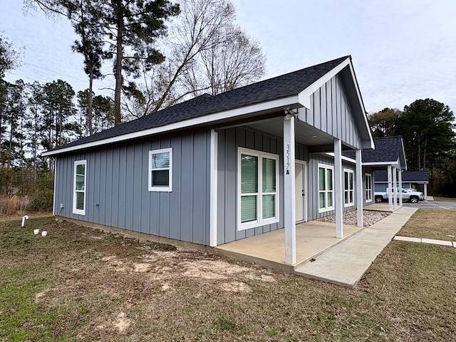 view of side of property with a yard and a patio