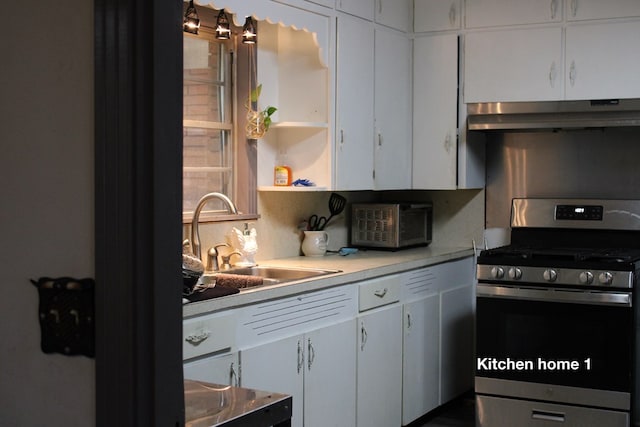 kitchen with gas range, sink, and white cabinets