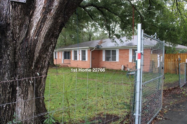 view of front of home with brick siding, a front yard, and fence