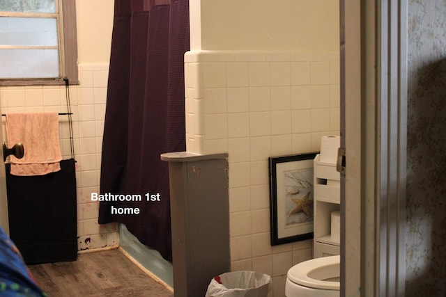 bathroom with wood-type flooring, toilet, and tile walls