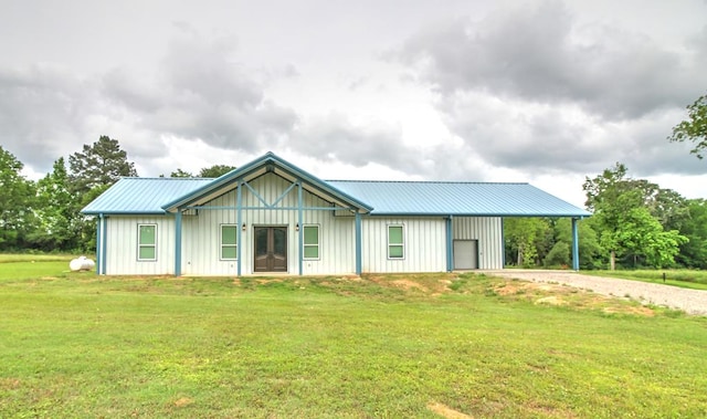 ranch-style house with a front lawn, board and batten siding, driveway, and metal roof
