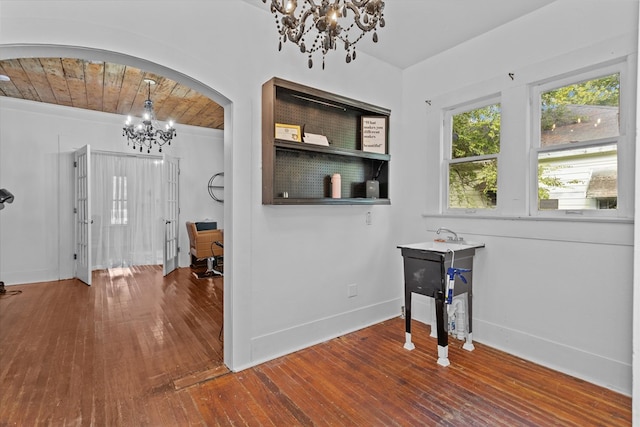 entryway featuring hardwood / wood-style floors, an inviting chandelier, and wooden ceiling