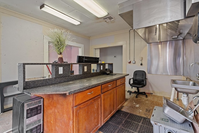 kitchen featuring heating unit, sink, dark tile patterned floors, and ornamental molding