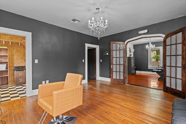 interior space featuring hardwood / wood-style flooring, an inviting chandelier, and french doors