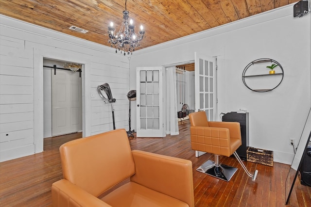 living area with hardwood / wood-style floors, wooden ceiling, french doors, a barn door, and a notable chandelier