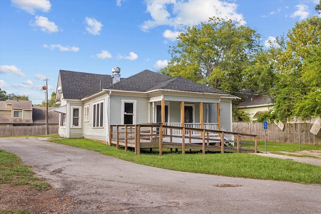 rear view of house featuring a lawn and a wooden deck