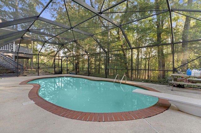 view of swimming pool with a diving board and a patio