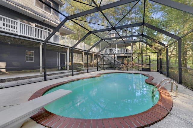 view of pool with a lanai, a diving board, and a patio area