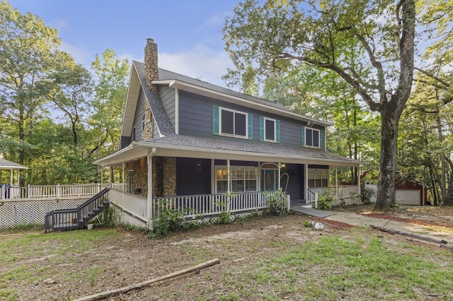 farmhouse inspired home with covered porch and an outbuilding