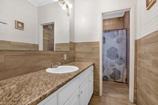 bathroom with hardwood / wood-style floors, vanity, walk in shower, and wooden walls