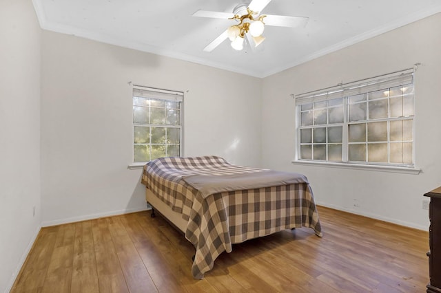 bedroom featuring ceiling fan, wood-type flooring, and crown molding