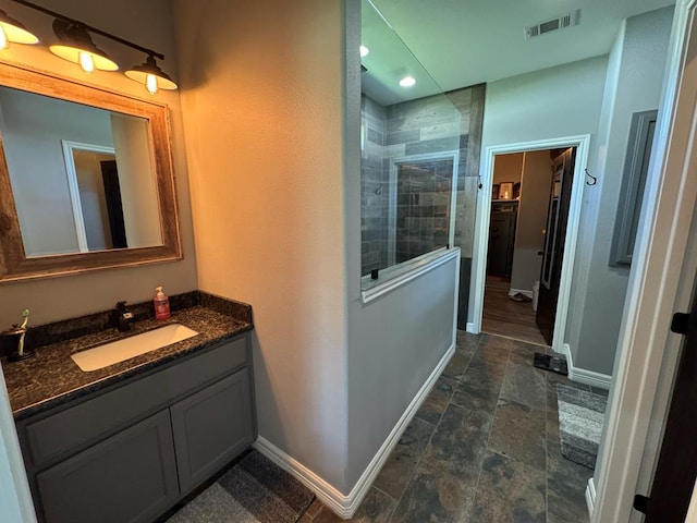 3640 Wingate Blvd, Brookeland, TX 75931 - bathroom featuring vanity, stone finish floors, tiled shower, and recessed lighting