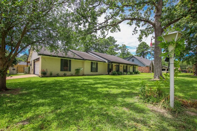 1308 Brook Holw, Lufkin, TX 75904 - rear view of property with an attached garage, a yard, concrete driveway, and brick siding