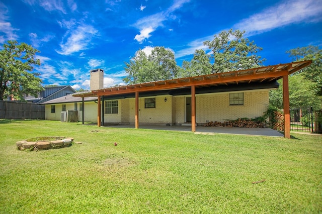 1308 Brook Holw, Lufkin, TX 75904 - rear view of house featuring a chimney, a patio, brick siding, and an outdoor fire pit