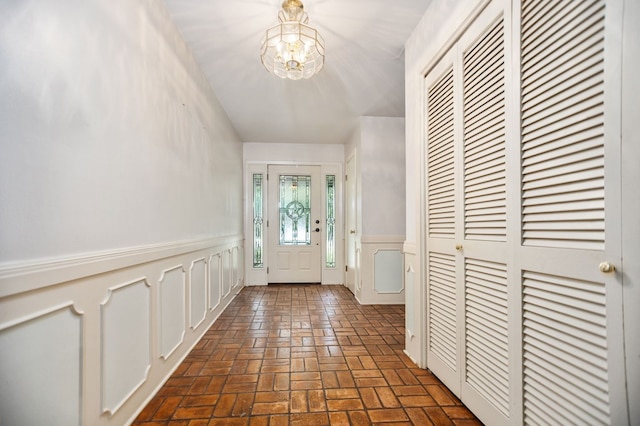 1308 Brook Holw, Lufkin, TX 75904 - foyer entrance featuring a chandelier, brick floors, and a wainscoted wall