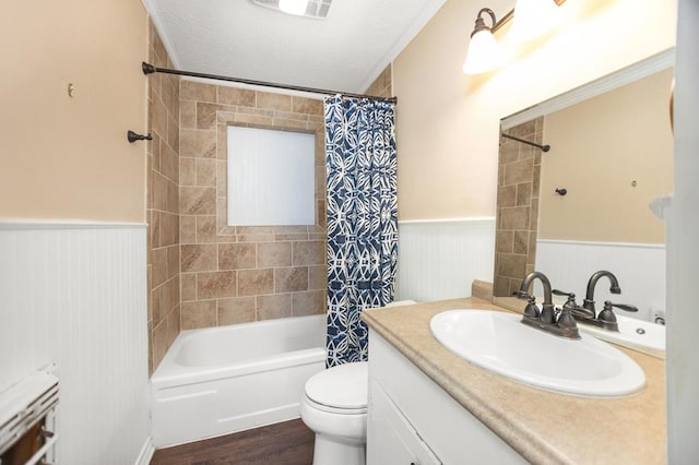 full bath with a wainscoted wall, toilet, vanity, and a textured ceiling