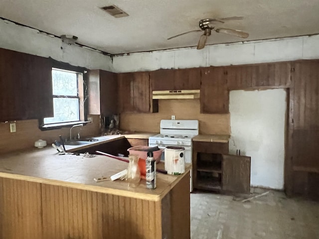 kitchen featuring sink, white gas range oven, ceiling fan, kitchen peninsula, and extractor fan