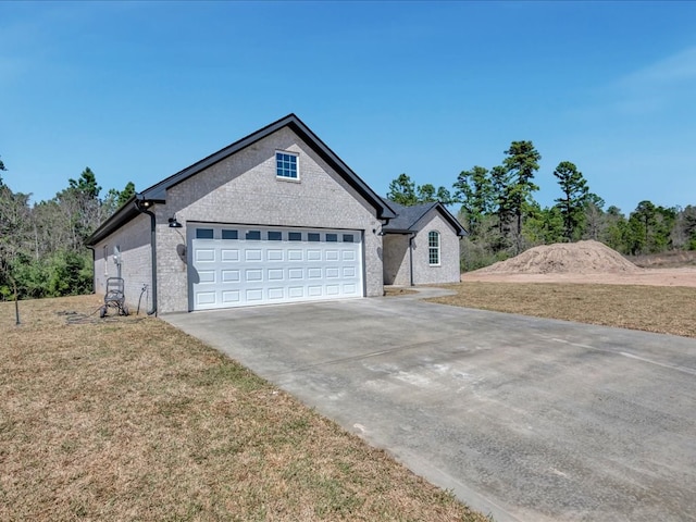 view of front of house with a garage, a front lawn, and driveway