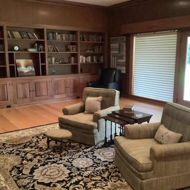 living area with built in shelves and wood-type flooring