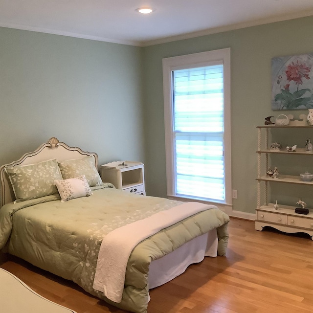 bedroom with wood-type flooring and ornamental molding