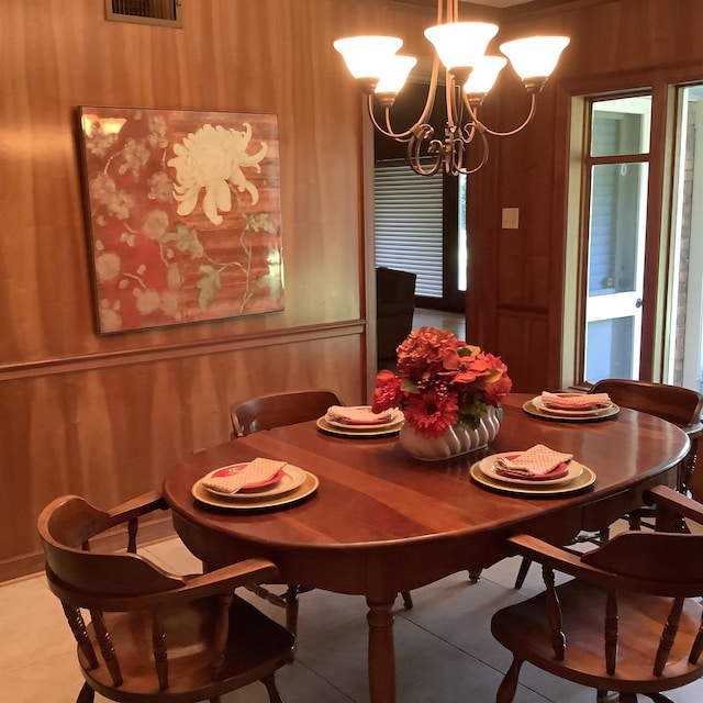 dining room with tile patterned flooring and a notable chandelier