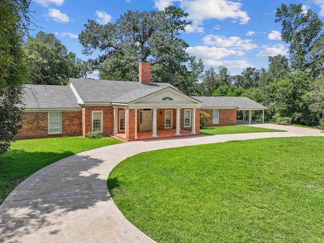 view of front of house featuring a front lawn, a porch, and a carport