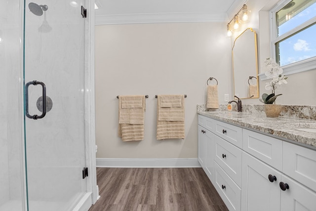 full bathroom with a shower stall, wood finished floors, a sink, and crown molding