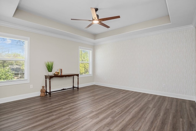 empty room featuring wallpapered walls, baseboards, a raised ceiling, and dark wood-type flooring