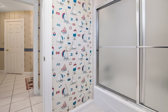 bathroom featuring bath / shower combo with glass door and tile patterned flooring