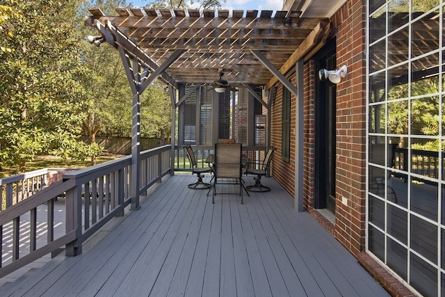 wooden terrace featuring outdoor dining space, ceiling fan, and a pergola