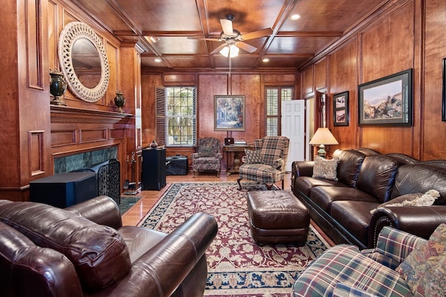 living area featuring wood walls, wood ceiling, coffered ceiling, and a ceiling fan