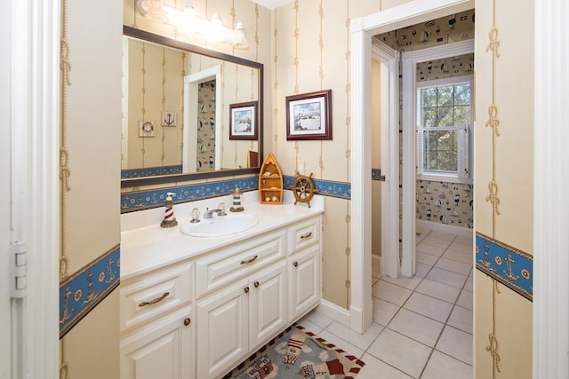 bathroom with tile patterned flooring, vanity, baseboards, and wallpapered walls