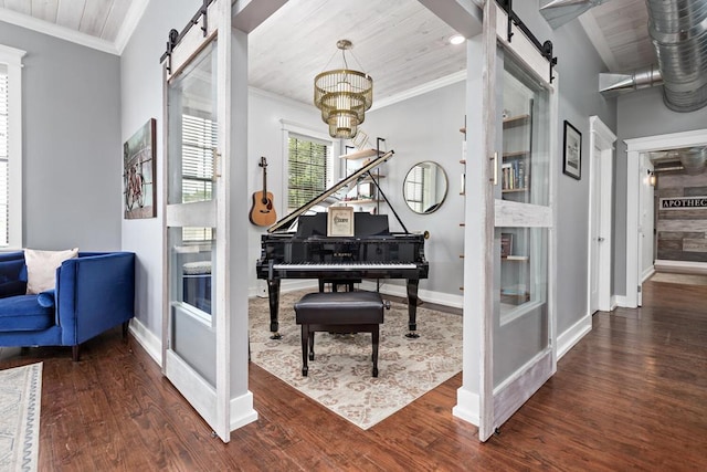 living area featuring baseboards, a barn door, and ornamental molding