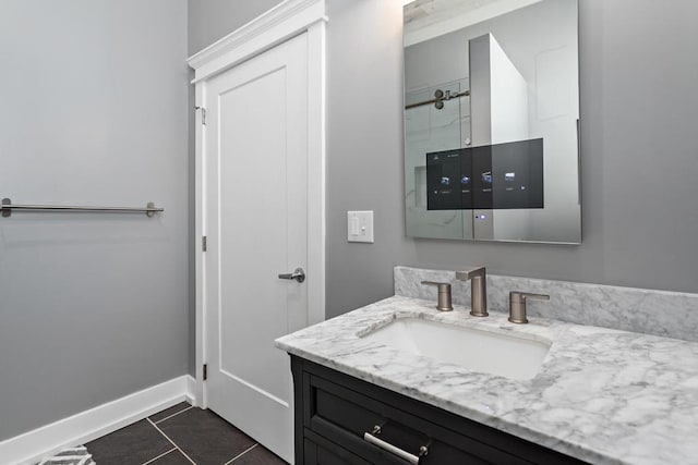 bathroom with vanity, baseboards, walk in shower, and tile patterned floors