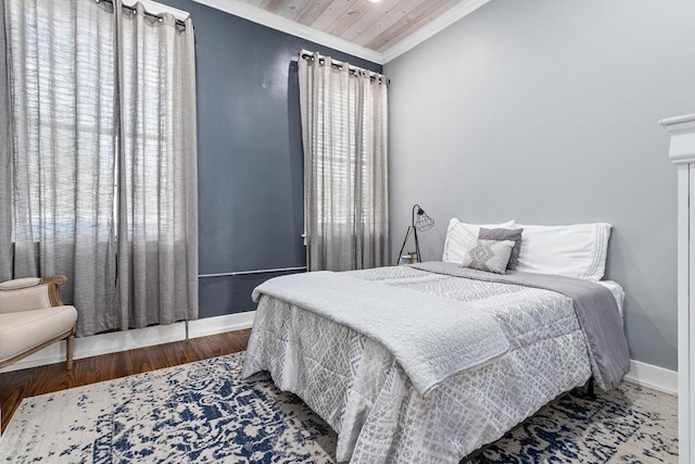 bedroom with baseboards, ornamental molding, and wood finished floors