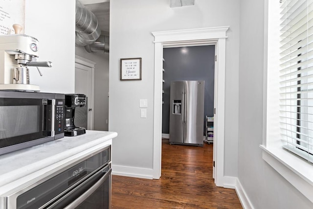hallway featuring baseboards and dark wood-style floors